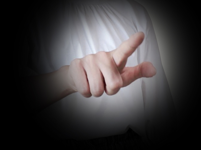 暗闇で指を指している人物